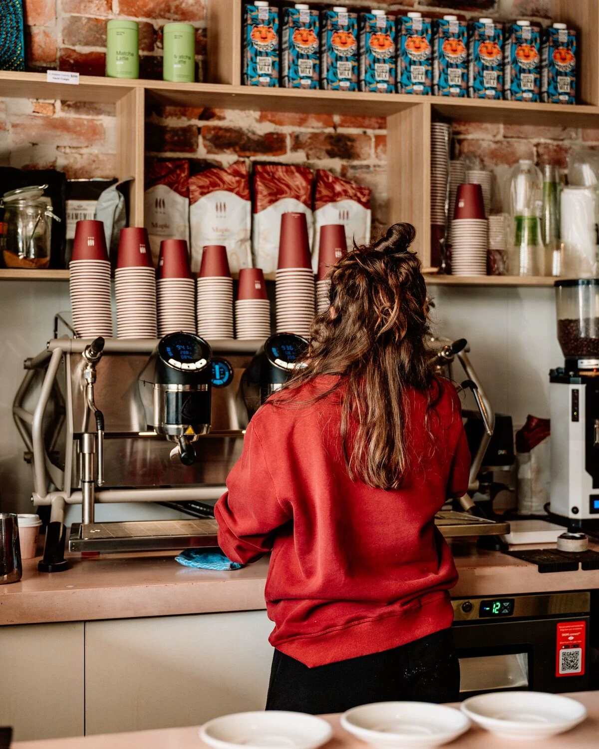 Barista preparing coffee behind the counter at Social Co Cafe
