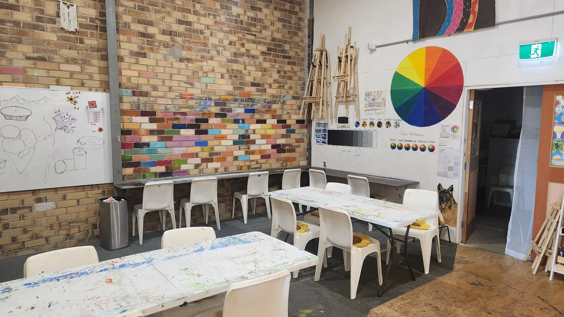Art studio at Social Co House with painting tables and a colour wheel mural on the wall