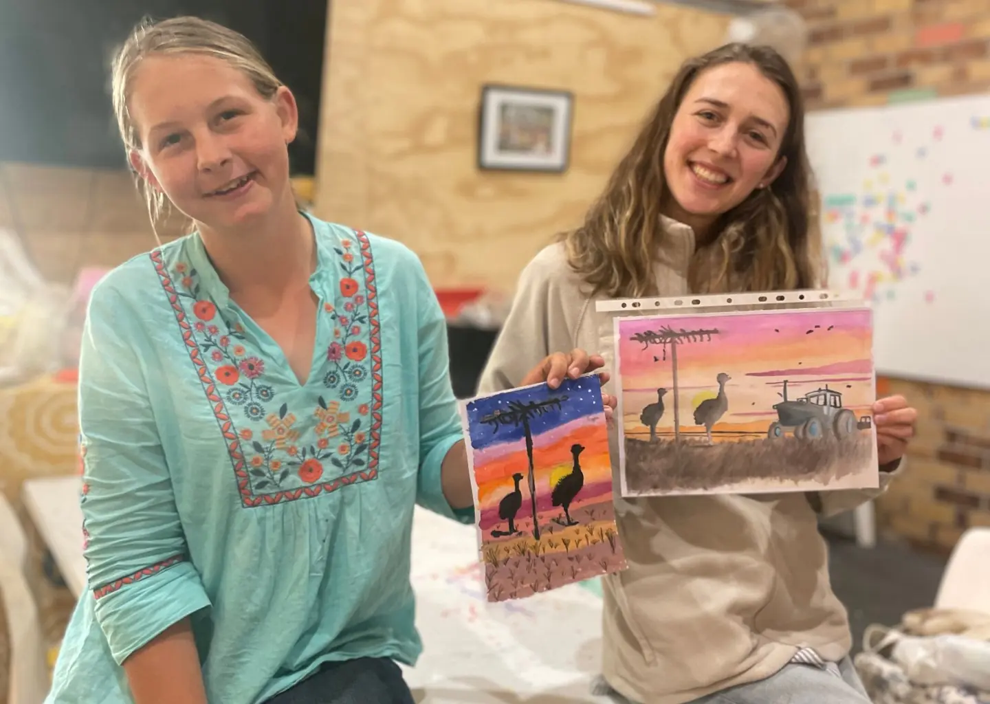 Two teens holding artwork created through Creating Space Teens in the art studio