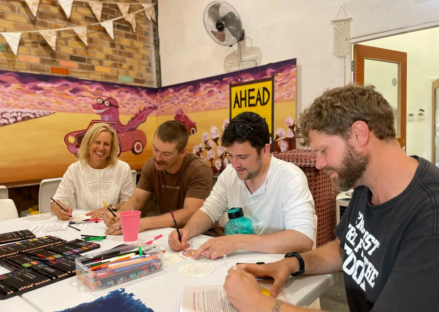 Adults working together on creative projects during Walk In Wednesday's in the art studio